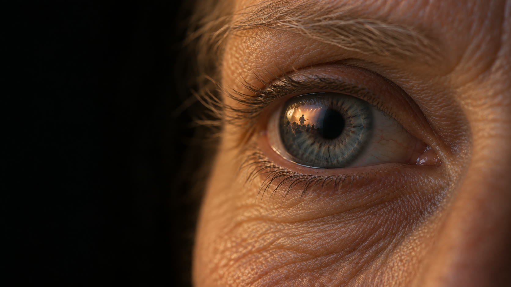 Close-up of an eye reflecting a concert stage
